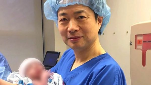 Médico John Zhang com o bebê nascido pela técnica de doação mitocondrial